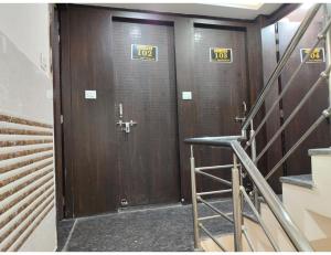 a pair of brown doors in a room with stairs at Hotel Avenue, Kanpur in Kānpur