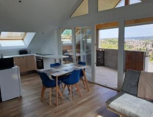 cocina y sala de estar con mesa y sillas en Appart’ terrasse vue exceptionnelle 1er étage en Montbéliard