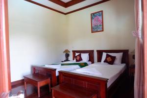 Postel nebo postele na pokoji v ubytování Kongmany Prestige Hotel