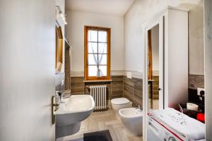 bagno con 2 lavandini, servizi igienici e finestra di Comfortable Home Vittoria Among Greenery - Happy Rentals a Marliana