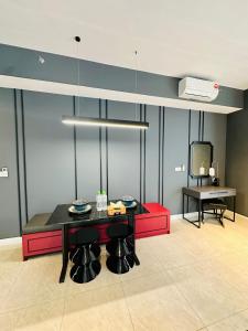 a dining room with a black table and red chairs at Axon Suites KL Pavilion in Kuala Lumpur