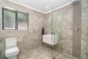 a bathroom with a toilet and a glass shower at Hout Bay Gem - Elise Way in Hout Bay