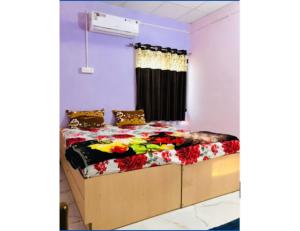een slaapkamer met een bed met bloemen erop bij Madhuvan Homestay, Junagarh in Sasan Gir