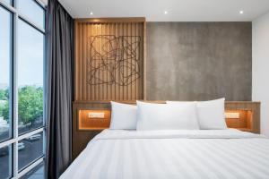 a bedroom with a bed and a large window at The Bayou Hotel Langkawi in Pantai Cenang
