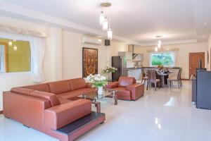 sala de estar con sofá y mesa en Family 3BR Villa Platinum, Private Pool, Gated Residence, in middle of Naiharn and Rawai Beach, en Rawai Beach