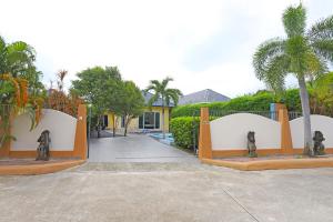 una puerta a una casa con palmeras y un camino de entrada en Family 3BR Villa Platinum, Private Pool, Gated Residence, in middle of Naiharn and Rawai Beach, en Rawai Beach