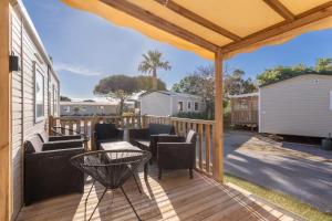 a patio with chairs and a table on a deck at Mobilhome Soleia 2023 Mar Estan 4x in Canet-en-Roussillon