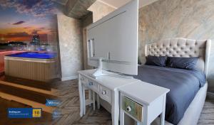 a bedroom with a bed and a desk with a television at Terrace Suites Iasi in Iaşi