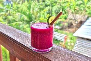 een drankje in een glas zittend op een leuning bij Ped Cottage in Nusa Penida