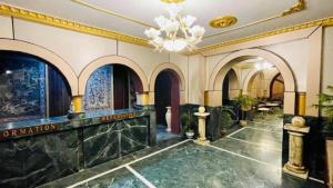 a lobby of a building with a chandelier at Hotel International Srinagar in Srinagar