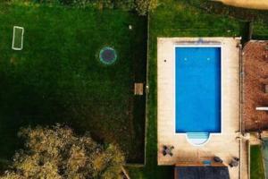 einen Blick über einen Pool auf einem Feld in der Unterkunft Castleford Cottage , Lowermill Estate in Somerford Keynes