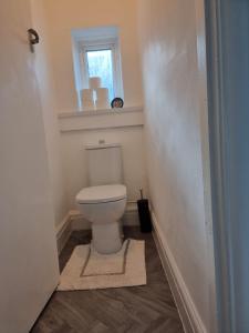 a bathroom with a toilet and a window at Radiant Accommodation Manor Lane in Plymouth