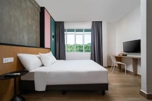 a hotel room with a bed and a desk at The Bayou Hotel Langkawi in Pantai Cenang