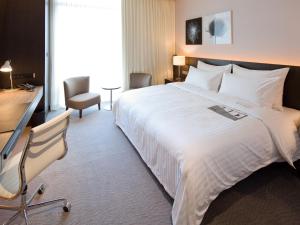 a hotel room with a large bed and a desk at Le Meridien Taipei in Taipei