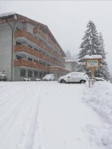una calle cubierta de nieve frente a un edificio en Monolocale a 150m da impianto di risalita Spinale CIPAT O22247-AT-O11471 en Madonna di Campiglio