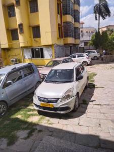 a white car parked in a parking lot with other cars at Goroomgo Varanasi Paradise Varanasi in Varanasi