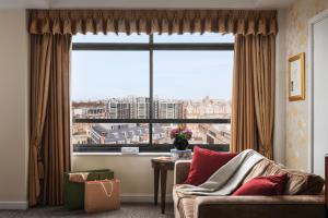 a living room with a large window and a couch at Millennium Hotel London Knightsbridge in London