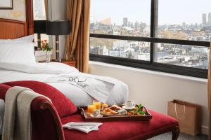 a hotel room with a tray of food on a bed at Millennium Hotel London Knightsbridge in London