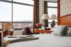 a hotel room with a bed and a large window at Millennium Hotel London Knightsbridge in London
