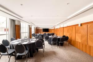einen Konferenzraum mit Tischen, Stühlen und einem Podium in der Unterkunft Millennium Hotel London Knightsbridge in London