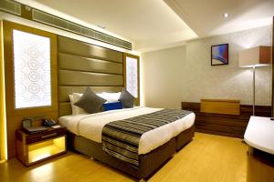 um quarto de hotel com uma cama grande e uma janela em Regenta Central the Crystal Kanpur, em Kanpur