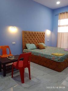 una camera con letto, sedia e tavolo di Shriya Inn a Malwan