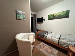 ein Schlafzimmer mit einem Bett, einem Stuhl und einem Bett in der Unterkunft Landhaus Pusteblume in Quedlinburg