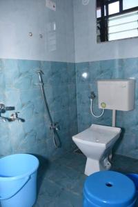 bagno blu con servizi igienici e lavandino di Shriya Inn a Malwan