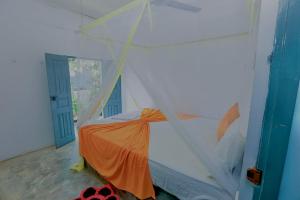 a bed in a room with a net at Kumudu Holiday Home in Hiriketiya