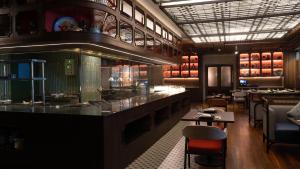 a restaurant with a bar and some tables and chairs at Amari Bangkok in Bangkok