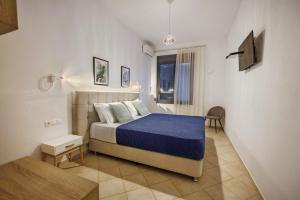 Schlafzimmer mit einem Bett mit blauer Decke in der Unterkunft Horizon Studios - Apartments in Rodakino