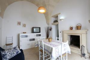 カストロ・ディ・レッチェにあるAppartamento Sant'Antonioのリビングルーム(テーブル、テレビ、暖炉付)
