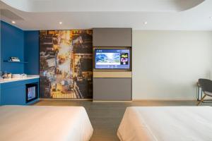 a hotel room with two beds and a flat screen tv at Atour Hotel Guangzhou Huadu Financial Center in Huadu
