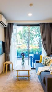 a living room with a couch and a table at Апартаменты в Laguna Skypark с террасой in Bang Tao Beach