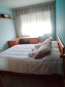 Schlafzimmer mit einem großen weißen Bett und einem Fenster in der Unterkunft Tu piso en el Camino de Santiago in Sarria
