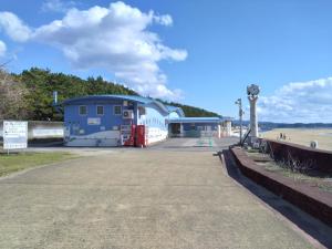 a building on the beach next to the beach at ゲストハウス　シン熊野 in Tanabe