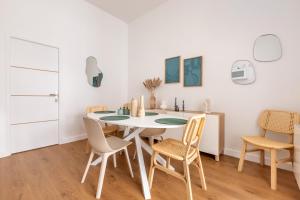 a dining room with a white table and chairs at Cosy T2 Charme confort - Cœur de Lille Sebastopol by Lity in Lille +11 photos