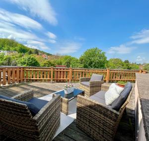 a patio with wicker chairs and tables on a deck at Landhaus Pusteblume in Quedlinburg