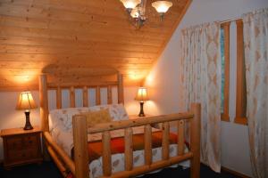een slaapkamer met een houten bed in een hut bij Hawthorn Cabin in Pine Glen