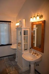 Baño con 2 lavabos y espejo en Hawthorn Cabin en Pine Glen