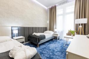 Habitación de hotel con 2 camas y alfombra azul en Wielka Pieniawa en Polanica-Zdrój