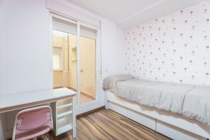 a bedroom with a bed and a desk and a window at Ca Vivi in Catarroja