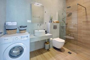 a bathroom with a washing machine and a sink at Horizon Studios - Apartments in Rodakino