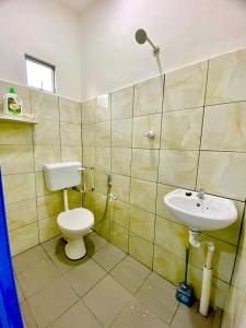 Suhana LongHouse HomeStay Sipitang في Sipitang: حمام مع مرحاض ومغسلة