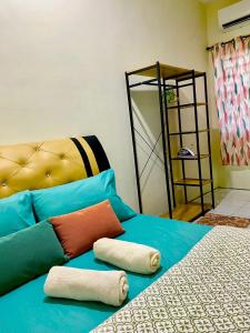 niebieskie łóżko z poduszkami na górze w obiekcie Suhana LongHouse HomeStay Sipitang w mieście Sipitang