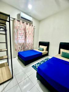 Suhana LongHouse HomeStay Sipitang في Sipitang: غرفة بسريرين وسرير بطابقين