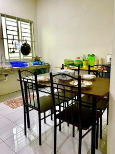 uma sala de jantar com uma mesa e quatro cadeiras em Suhana LongHouse HomeStay Sipitang em Sipitang