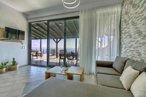 a living room with a couch and a view of the ocean at Horizon Studios - Apartments in Rodakino