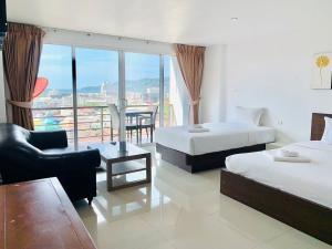 a hotel room with two beds and a balcony at Oceanview Treasure Hotel and Residence in Patong Beach