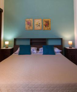 a bedroom with a large bed with blue pillows at B&B Del Viale in Bacu Abis